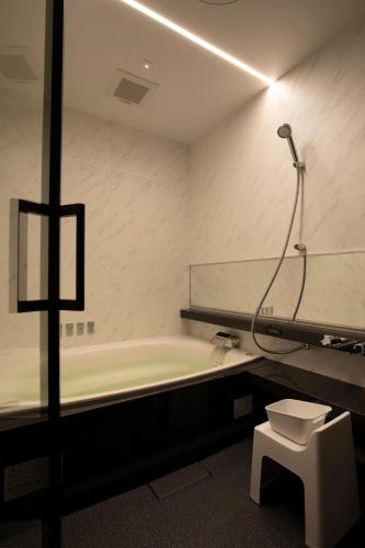a bathroom with a bath tub and a toilet at 宮島離れの宿 IBUKU -Miyajima Hanare no Yado IBUKU- in Miyajima