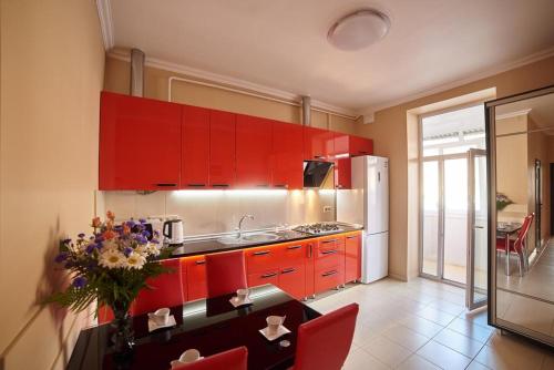 リヴィウにある2 Bedrooms Apartment 150m from Opera Houseの赤いキャビネットと花瓶付きのキッチン