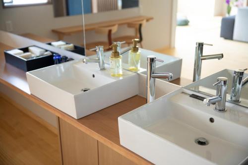 a bathroom counter with two sinks and a mirror at 宮島離れの宿 IBUKU -Miyajima Hanare no Yado IBUKU- in Miyajima