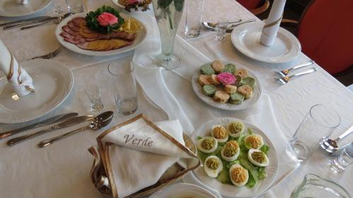 a white table with plates of food on it at Restauracja i Pokoje Gościnne Verde in Sokółka