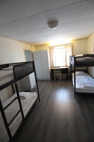 a room with three bunk beds and a window at Economy Apartments Peura in Rovaniemi
