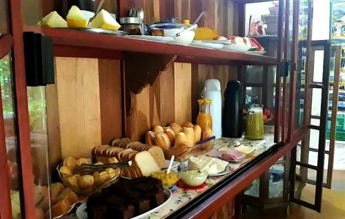 a shelf filled with lots of different types of food at Pousada Casa do Cerrado - Alto Paraíso de Goiás in Alto Paraíso de Goiás