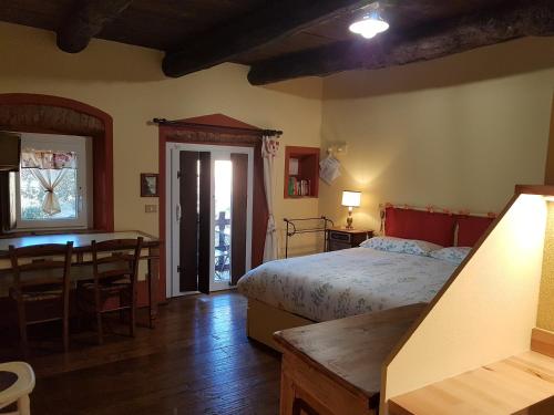 1 dormitorio con cama, mesa y escritorio en B&B La Cascina di Monia e Mario, en Borgo Ticino