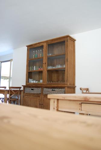 a wooden cabinet in a room with a table at La Ferme du Chauchix in Lamballe
