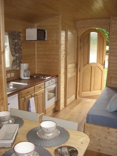 a small kitchen with a table in a log cabin at La Ferme du Chauchix in Lamballe