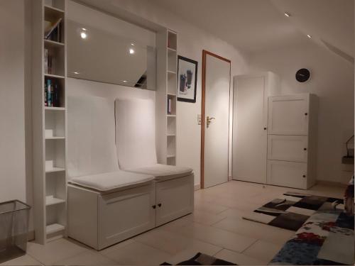 una sala de estar con paredes blancas y estanterías blancas en FeWo Lüneburger Heide - Hans-Hermann, en Bad Bevensen