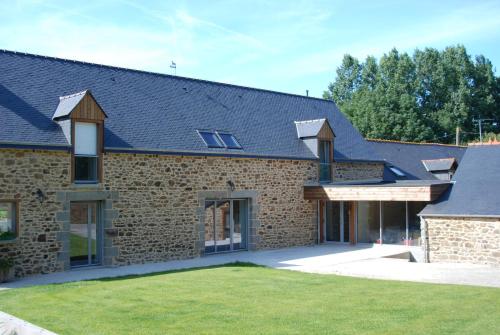 una casa de ladrillo con techo de gambrel en La Ferme du Chauchix en Lamballe