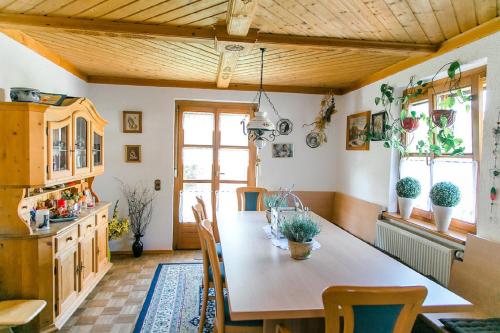 Hohes Ferienhaus في هايليغنشتات: مطبخ مع طاولة وكراسي في غرفة