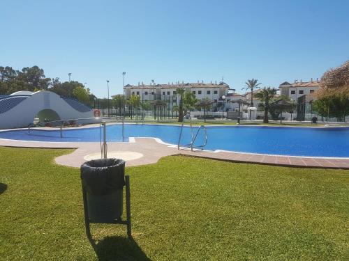 a swimming pool with a playground in a park at Taymar in Chiclana de la Frontera
