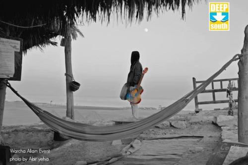 a person standing in a hammock on the beach at Deep south Eco-lodge in Marsa Alam City