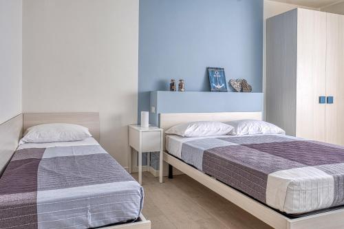 - 2 lits dans une chambre aux murs bleus dans l'établissement Katy Apartment, à Lido di Jesolo