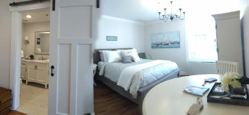 a bedroom with a bed and a table and a mirror at Harbor House Inn in Sackets Harbor