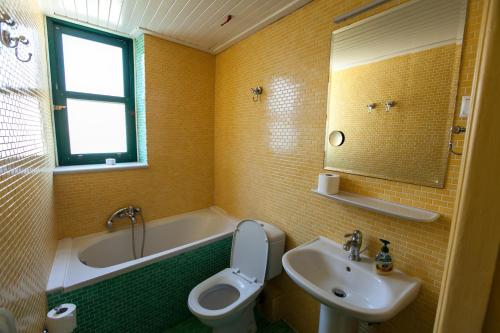 La salle de bains est pourvue d'un lavabo, de toilettes et d'une baignoire. dans l'établissement Tis Mammis, à Nauplie