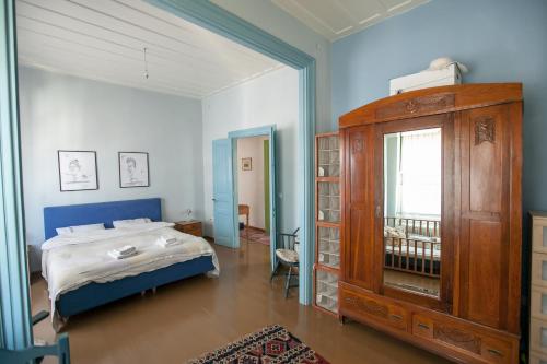 1 dormitorio con 1 cama y armario de madera en Tis Mammis, en Nauplia