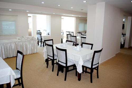 a dining room with white tables and chairs and a table and chairsktop at Anya Suit Otel in Denizli