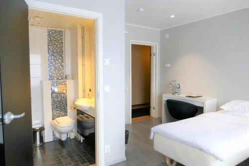 1 dormitorio con 1 cama y baño con lavamanos en Linnanpiha Bed & Breakfast en Rauma