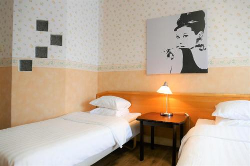 a hotel room with two beds and a picture on the wall at Linnanpiha Bed & Breakfast in Rauma