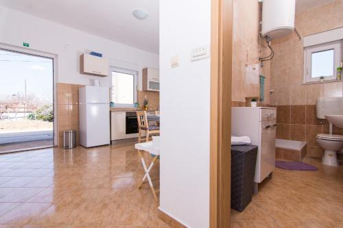 a kitchen and living room with a refrigerator and a sink at Apartments Marinera in Trogir