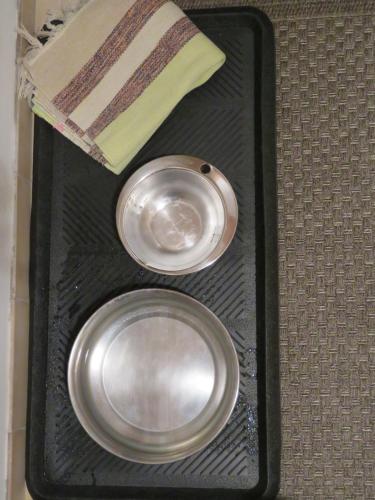 two metal plates in a black tray with a book at Ecrin de Verdure in Sainte-Suzanne