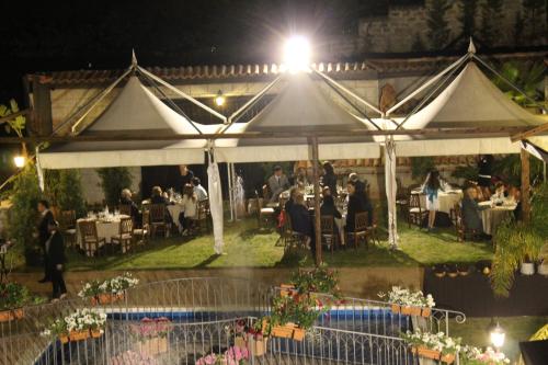 a group of people sitting under a white tent at B&B Montereale in Monreale