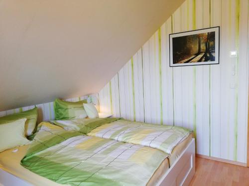 a bed in a room with a striped wall at Privatzimmer mit Aussicht in Pirna