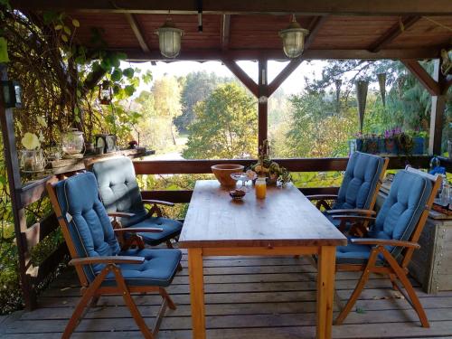 a wooden table and chairs on a deck at Birchy Hills in Sitno
