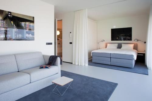 a living room with a couch and a bed at Urban Residences Rotterdam in Rotterdam