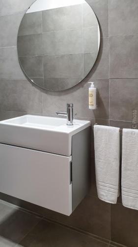 a bathroom with a white sink and a mirror at CC Guest House - "Ao Mercado" in Ponta Delgada