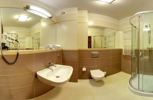 a bathroom with a sink and a toilet and a shower at Hotel Dudek in Mniów