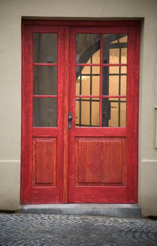 a red door with a window on a building at Křišťanka - kouzelné apartmány in Prachatice