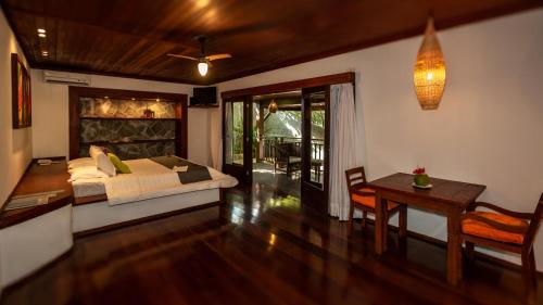 a bedroom with a bed and a desk and a table at Sombra e Água Fresca Floresta in Pipa