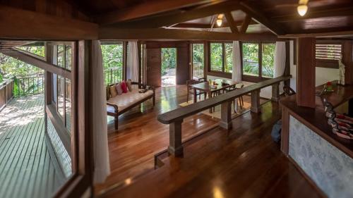a living room with wooden flooring and glass windows at Sombra e Água Fresca Floresta in Pipa
