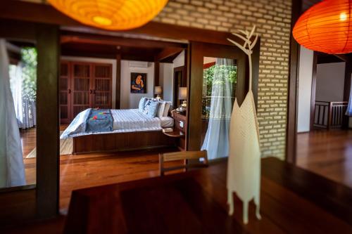a bedroom with a bed and a large mirror at Sombra e Água Fresca Floresta in Pipa