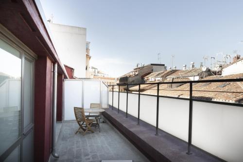 a balcony with a table and a train on the tracks at Petit Palace Plaza Mayor in Madrid