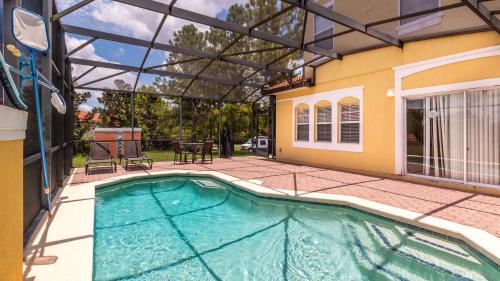 una piscina in una casa con pergolato di Encantada Rose - a 4 bed townhouse near Disney a Kissimmee