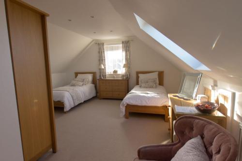 a attic room with two beds and a window at Pen Llyn Bed and Breakfast in Dinas