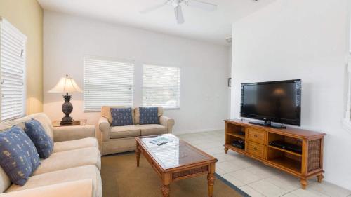 a living room with a couch and a tv at Encantada Rose - a 4 bed townhouse near Disney in Kissimmee