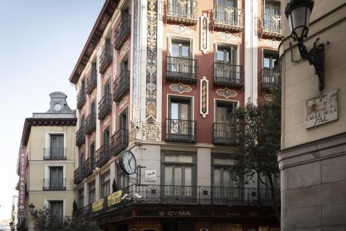 um edifício com um relógio na lateral em Petit Palace Posada del Peine em Madrid