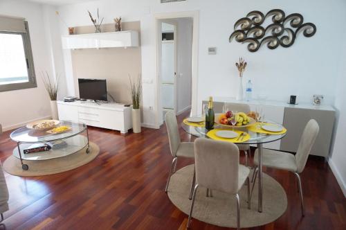 ein Wohnzimmer mit Tisch und Stühlen und ein Esszimmer in der Unterkunft Happy Holiday Beach Home in Sitges