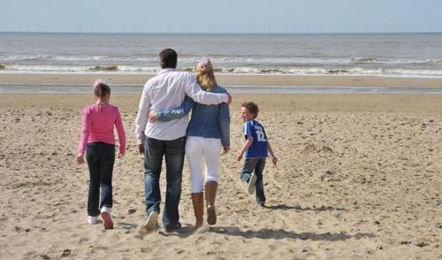 a group of people walking on the beach at Appartementen Natuurlijk in Egmond aan Zee