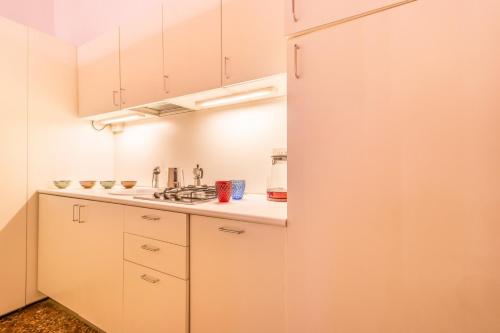 een keuken met witte kasten en een koelkast bij Fenice Backstage over Canal in Venetië