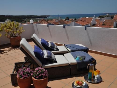 a couch sitting on top of a patio next to a pool at Mil Reis in Vila Nova de Milfontes
