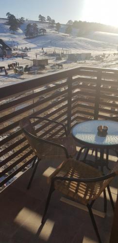 a table and chair on a balcony overlooking the beach at Apartment GEA 24 Zlatibor sa garažom in Zlatibor