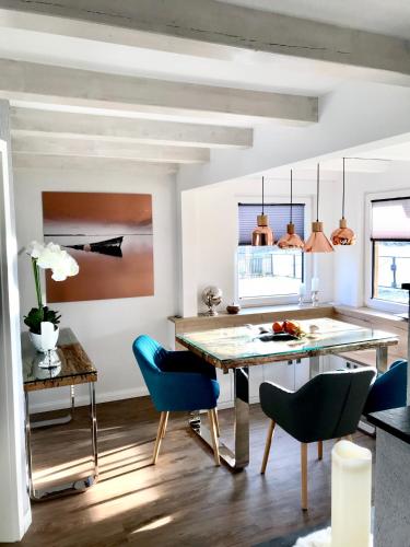 Una cocina con una mesa de comedor y sillas azules. en Ferienhaus am Dachsberg, en Bad Saarow