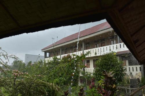 a large white building with a red roof at PIAS POPPIES HOTEL in Rantepao