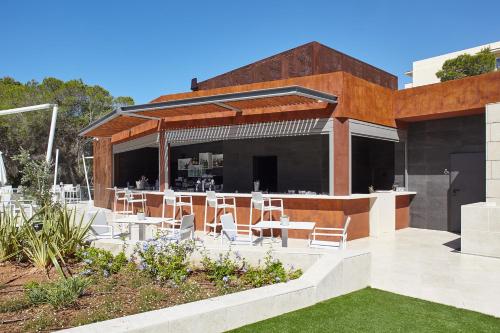 a patio with tables and chairs in front of a building at Iberostar Selection Llaut Palma- Adults Only in Playa de Palma