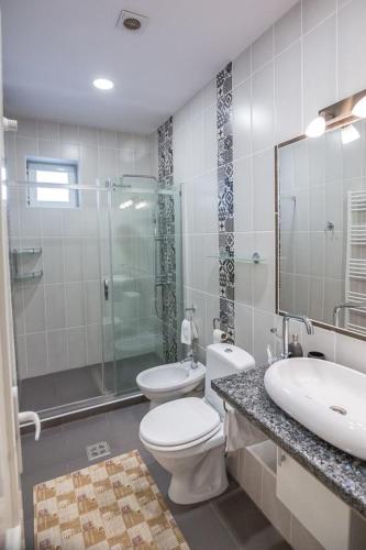 a bathroom with a toilet and a sink and a shower at Pensiunea San Gennaro in Miercurea-Ciuc
