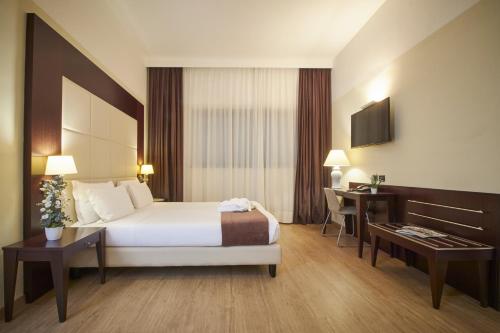 米兰iH Hotels Milano Watt 13的带床和书桌的酒店房间