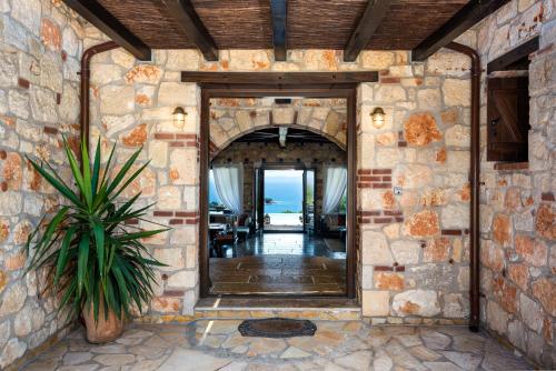 an entrance to a house with a stone wall at Sithonian Blue Royal Villa in Nikiti