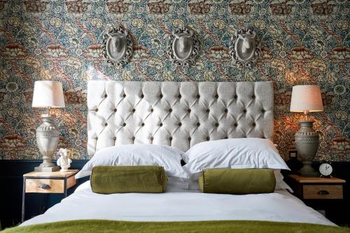 a bedroom with a large bed with a large headboard at The Fleece at Cirencester in Cirencester